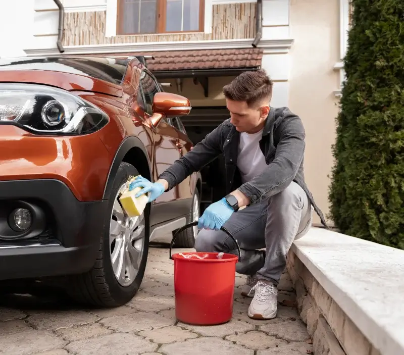 Lavage auto à domicile Val-de-Livenne : professionnel intervenant sur un véhicule